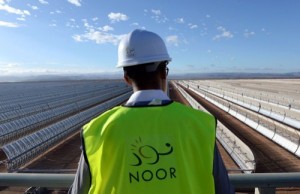 TO GO WITH AFP STORY BY JALAL AL-MAKHFI - A picture taken on October 17, 2015 shows a worker standing in front of solar mirrors at the Noor 1 Concentrated Solar Power (CSP) plant, some 20km (12.5 miles) outside the central Moroccan town of Ouarzazate. On the edge of the Sahara desert, engineers make final checks to a sea of metal mirrors turned towards the sun, preparing for the launch of Morocco's first solar power plant, that has half a million U-shaped mirrors -called "parabolic troughs"- stretch out in 800 rows, slowly following the sun as it moves across the sky. AFP PHOTO / FADEL SENNA